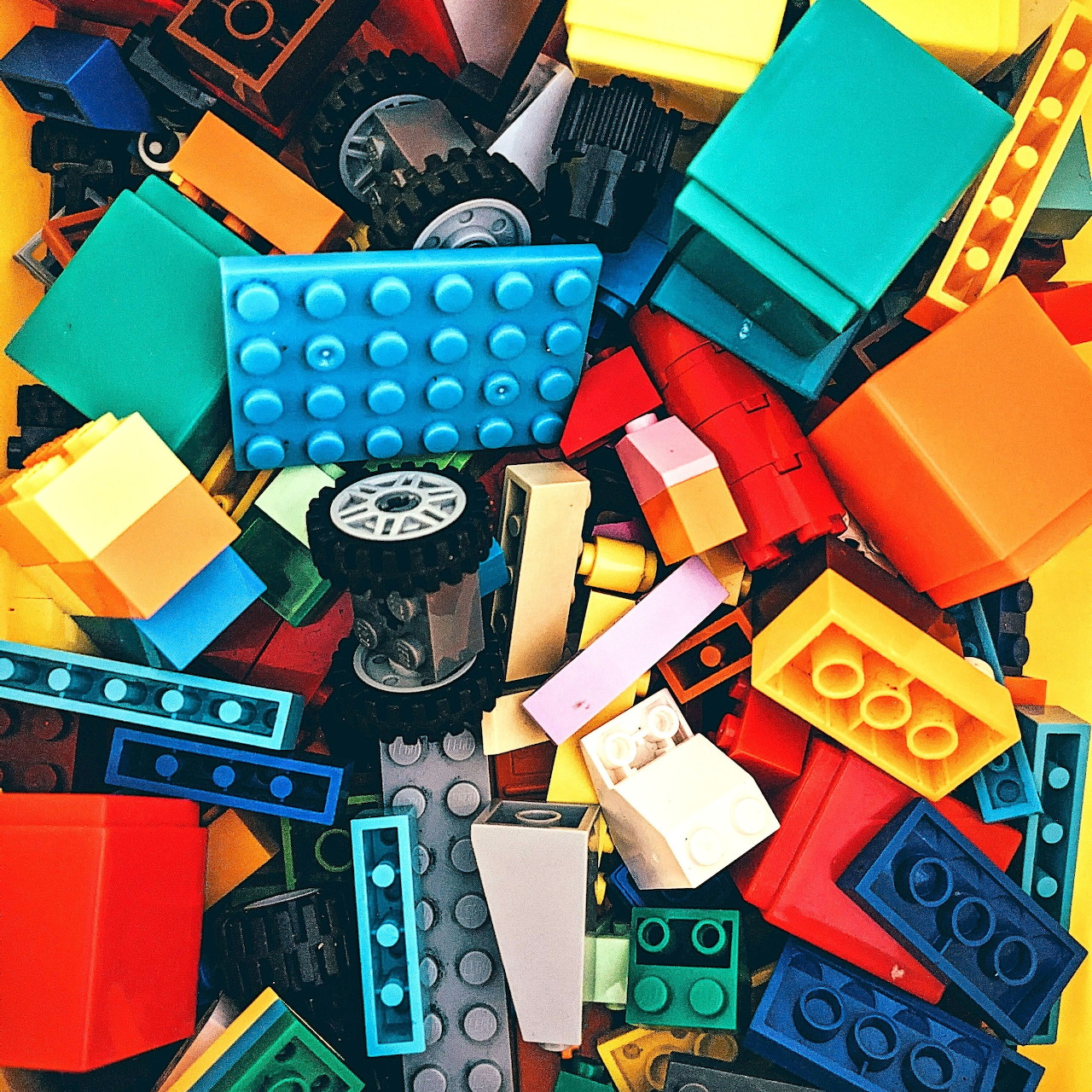 Close-up of colorful toy building bricks and plastic parts scattered in a pile