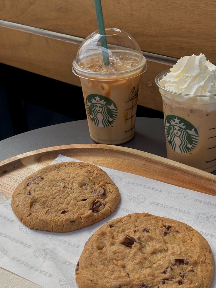 Two iced coffee drinks and two chocolate chip cookies on a tray