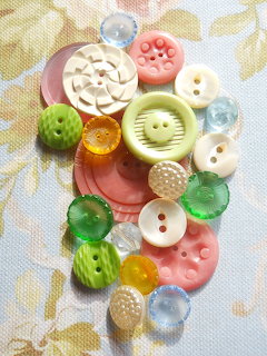 Collection of colorful vintage buttons in various shapes and sizes on floral fabric