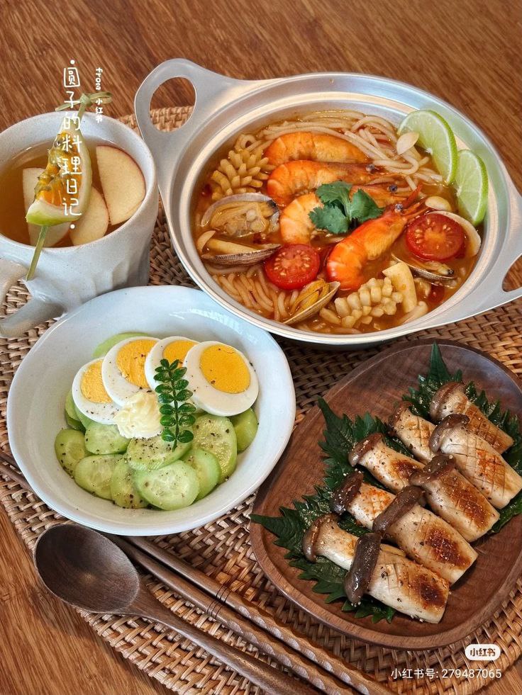 Top-down view of Korean meal with spicy seafood hotpot, cucumber egg salad, and grilled fish slices