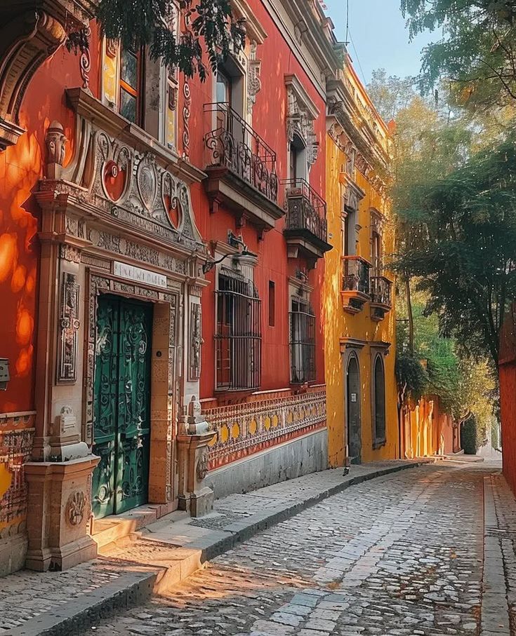 Colorful colonial street with red and yellow buildings, ornate balconies, and coblestone pavement