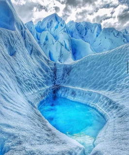 Bright turquoise meltwater pool carved into the blue-white ice of Perito Moreno Glacier, Argentina