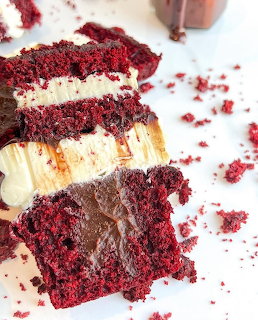 Close-up of red velvet cake slices with cream cheese frosting and crumbs