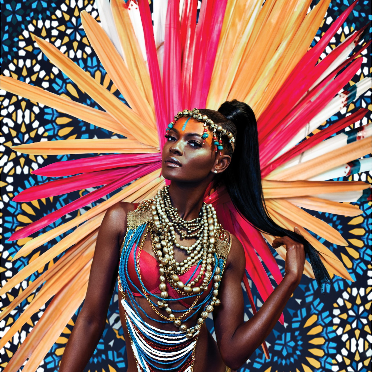 Woman wearing colorful Trinidad Carnival costume with radiating feathered headdress and beaded jewelry