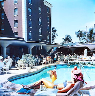 Vintage poolside scene at the Colony Hotel with seated guests and a sunbather in Palm Beach, Florida