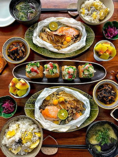 Overhead view of a Korean meal spread on a wooden table with multiple dishes and side plates