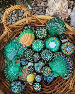 Woven basket filled with seashells and stones decorated with turquoise and gold mandala dot art patterns