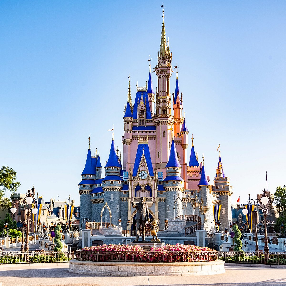 Ornate blue and gold fairy tale castle with multiple turrets and spires against clear sky