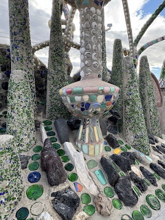 Colorful mosaic sculpture surrounded by tiled columns and stone forms outdoors