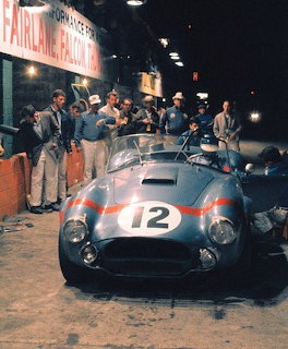 Shelby Cobra #12 in pit lane at 1964 Sebring race with crew members gathered around
