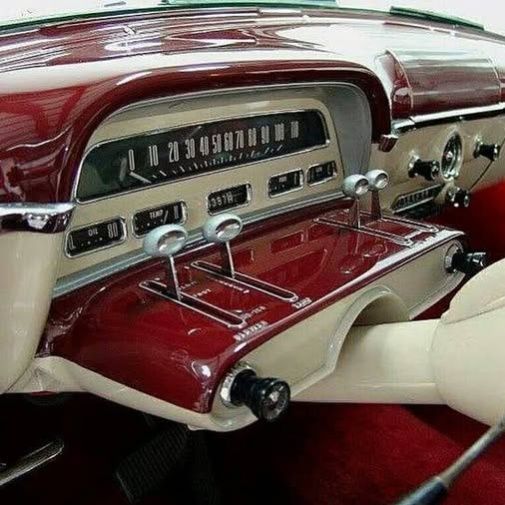 Close-up of a red and cream 1954 Mercury Monterey dashboard and front interior