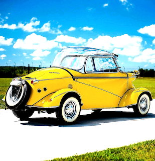 Yellow vintage Messerschmitt microcar with white top on grass field under blue sky