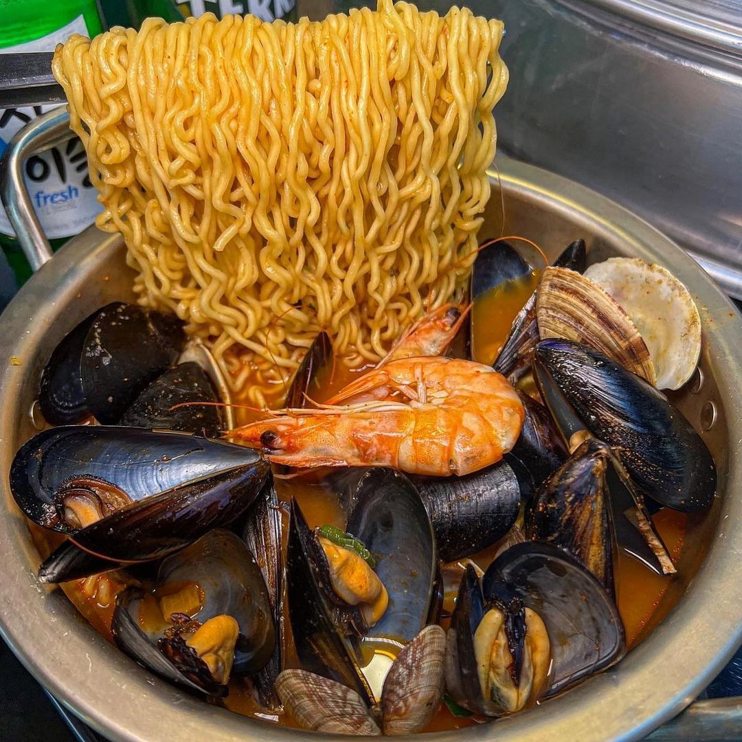 Bowl of instant ramen noodles with mussels and shrimp in broth