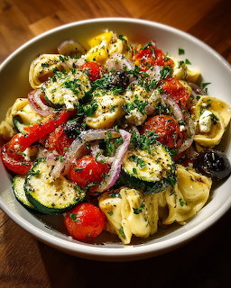Bowl of pasta with roasted vegetables, tomatoes, zucchini, olives and herbs