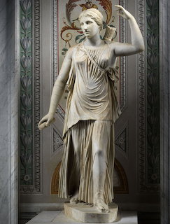 Classical marble statue of Artemis in a decorated wall niche