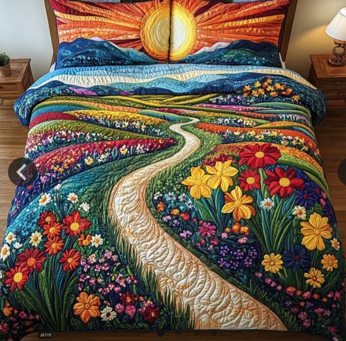 Colorful quilted bedspread on a bed with a river, flowers, hills, and sun design