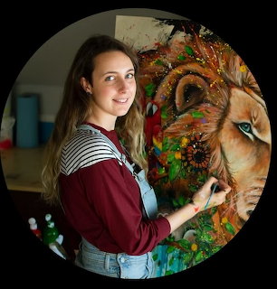 Young woman in striped shirt painting a colorful lion on canvas
