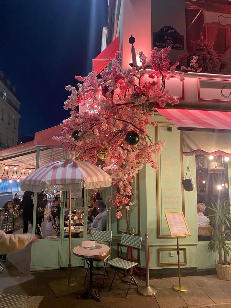 Parisian cafe at night with flowers and Eiffel Tower in background