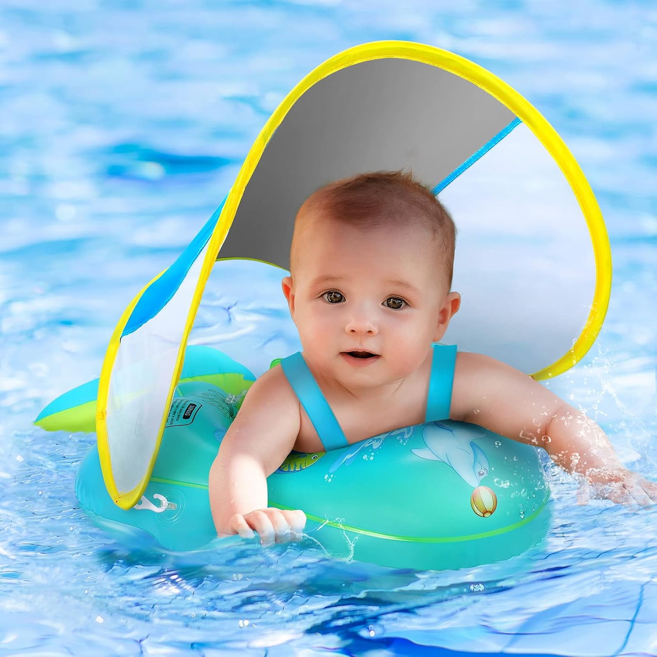Baby in turquoise float with yellow canopy in pool