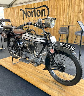 Vintage 1921 Norton Big 4 motorcycle on display indoors with a Norton sign behind it
