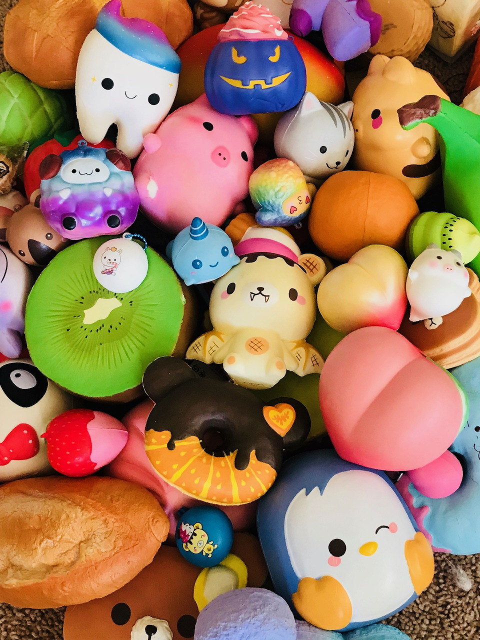 Pile of colorful kawaii squishy toys including animals, food shapes, and cute characters