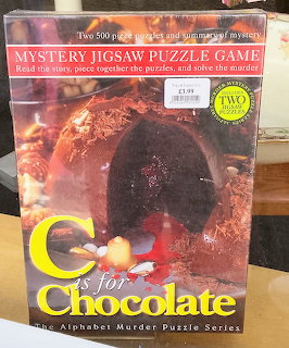 Mystery jigsaw puzzle game box with a dark chocolate dessert image on the cover