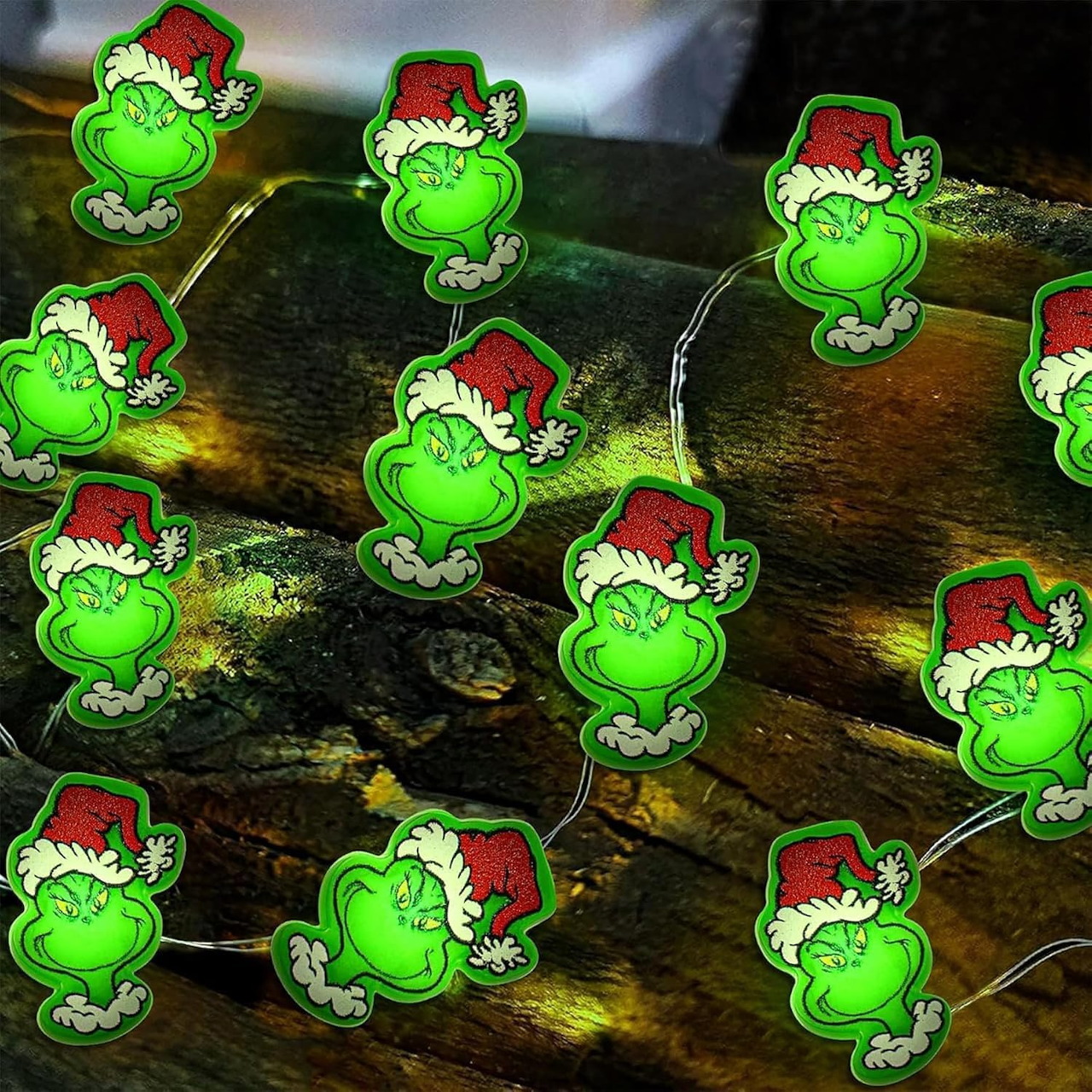 Grinch-themed Christmas string lights on a dark wooden surface