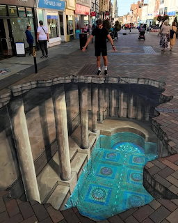 3D sidewalk chalk art creating illusion of classical columns and decorated floor on pedestrian street