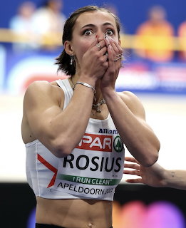 Female athlete Rosius covering her mouth in shock after an indoor sprint race