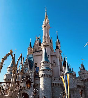 Ornate Disney castle with multiple turrets and spires under clear blue sky