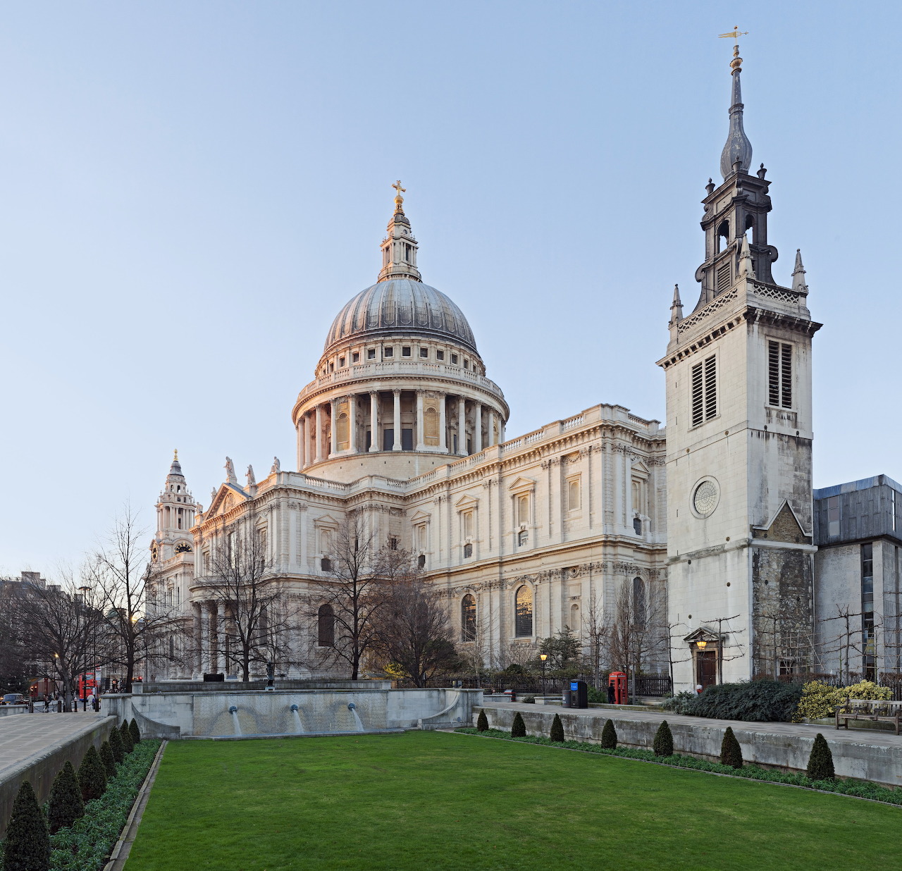 St Paul's Cathedral with dome and towers, green lawn in foreground, cloudy sky above