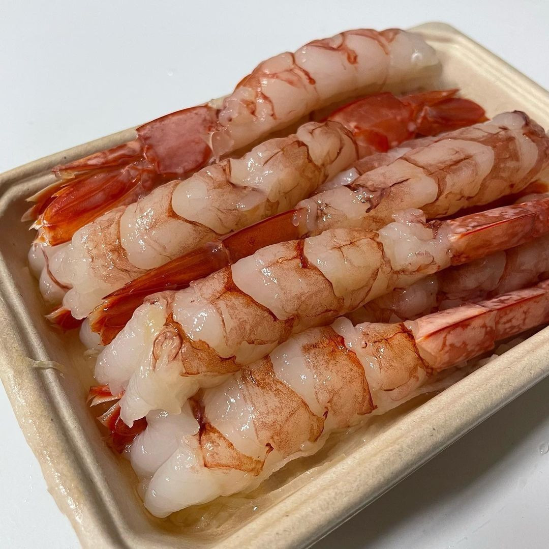 Close-up of raw shrimp sashimi arranged in a small tray