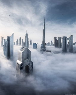 Dubai skyline with Burj Khalifa and skyscrapers emerging above sea of clouds