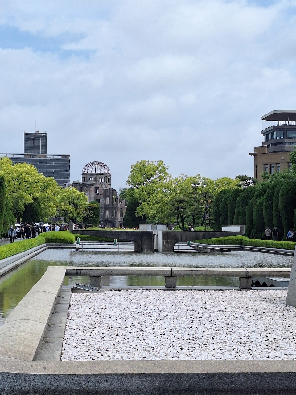 Hiroshima Peace Memorial Park with A-Bomb Dome, reflecting pool, and green trees in the background