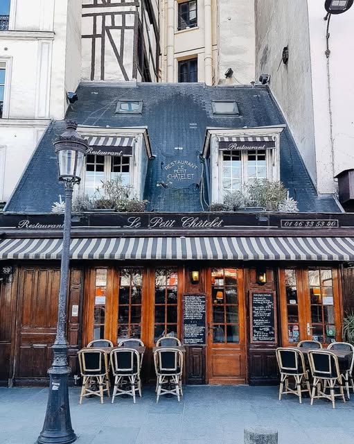 Old traditional restaurant facade in Paris with vintage signage and classic French architecture