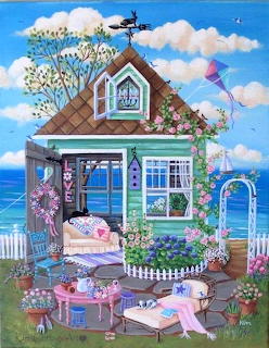 Blue cottage with garden and white fence overlooking the sea, flowers in foreground, kite flying in cloudy sky