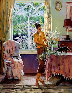 Woman in yellow sweater arranging flowers in a sunny room with patterned curtains and furniture