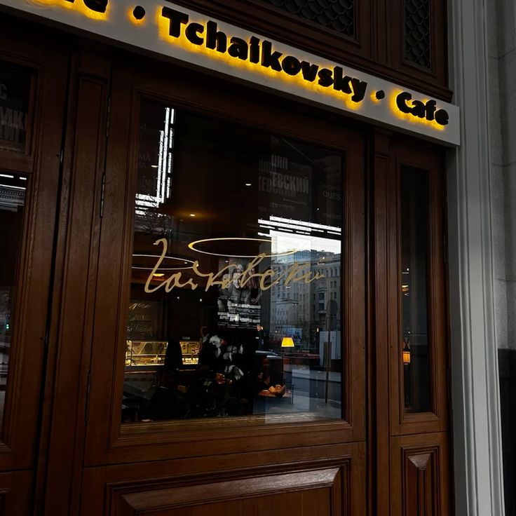 Tchaikovsky Cafe storefront with yellow sign and wooden entrance at dusk