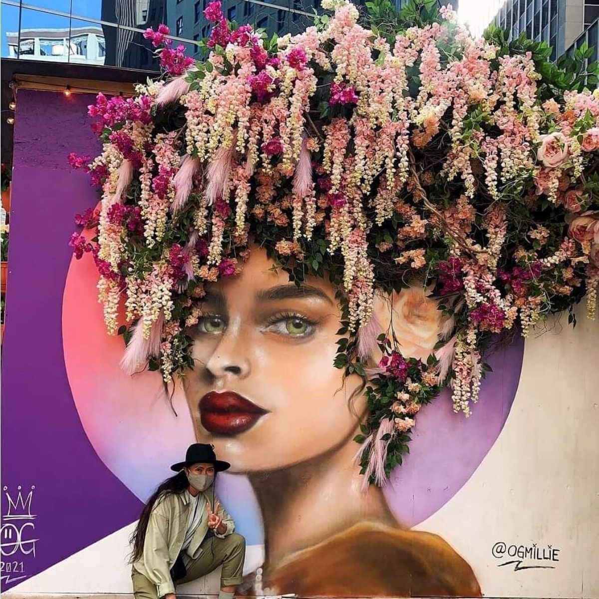 Street art portrait of woman with floral hair crown, purple background, red lips, dramatic eye makeup