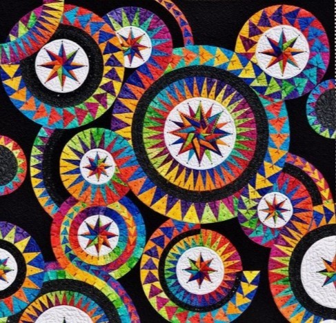 Vibrant quilt with overlapping circular star compass patterns in many colors on black