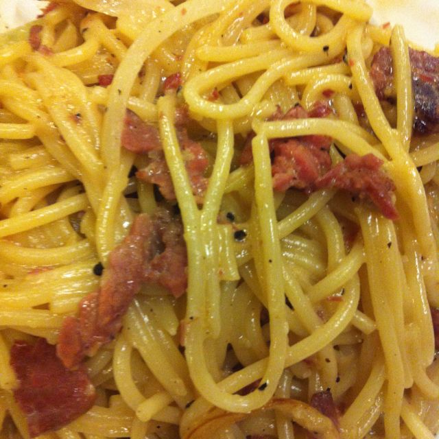 Close-up of spaghetti carbonara with bacon on white plate