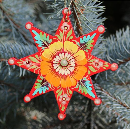 Hand-painted wooden star ornament with folk art floral pattern on Christmas tree