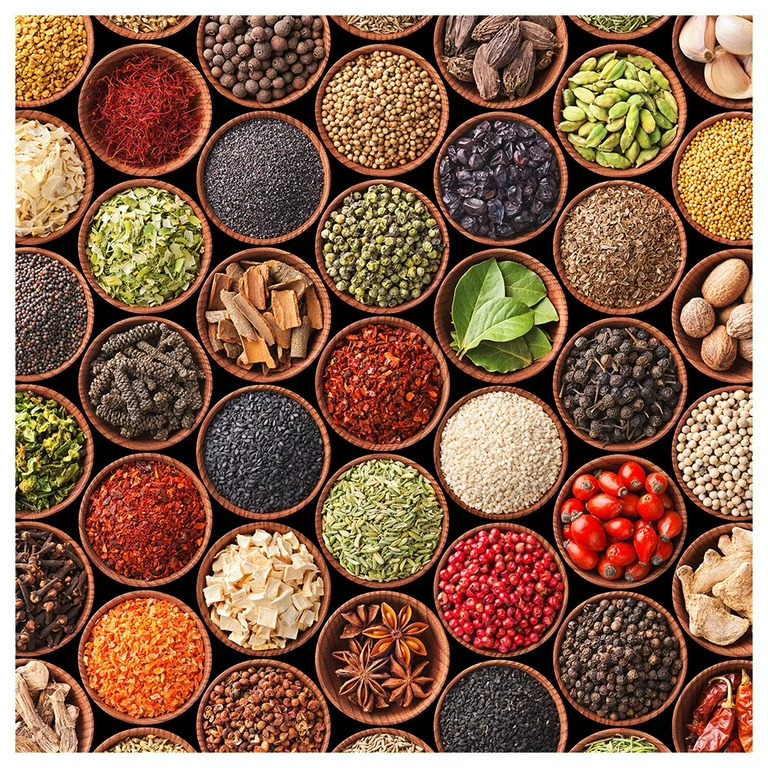 Assorted colorful spices and herbs in small round bowls arranged from above