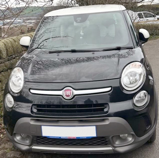 Front view of a black Fiat 500L car parked outdoors