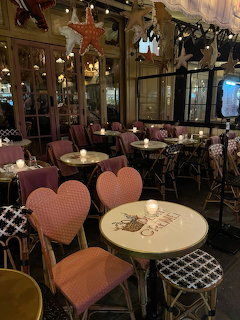Cozy cafe interior with round tables, heart-shaped chairs, and warm decorative lighting