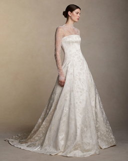 Woman in white lace wedding dress with sheer long sleeves posing in profile view