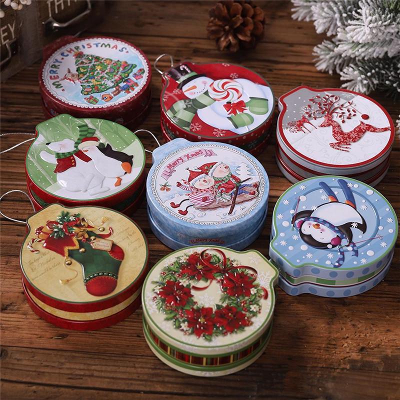Eight round Christmas tins with holiday illustrations on a wooden table