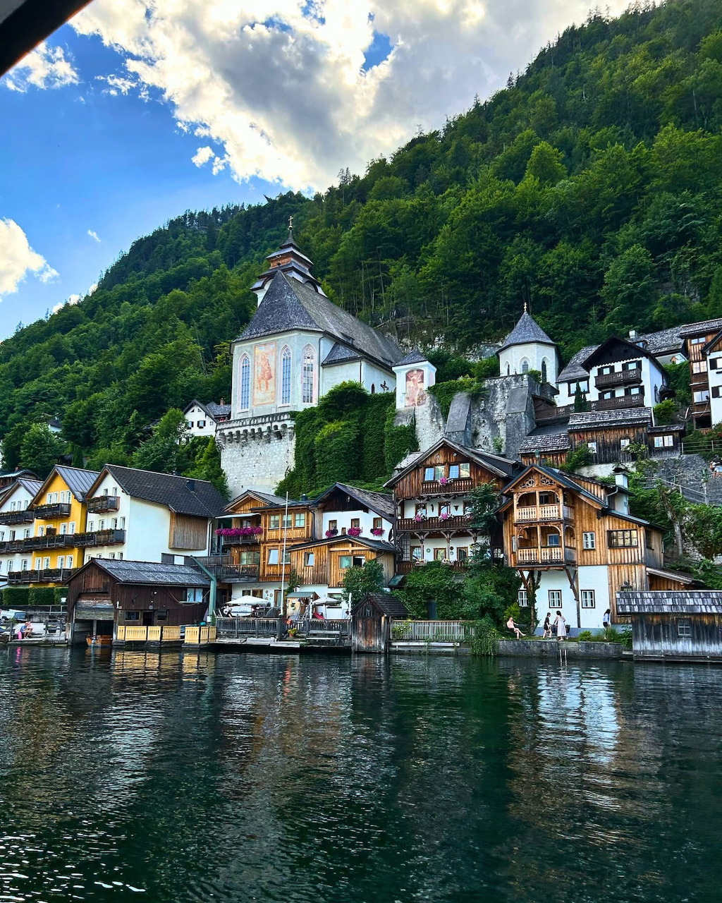 Hallstatt village with church and colorful houses on mountainside beside lake