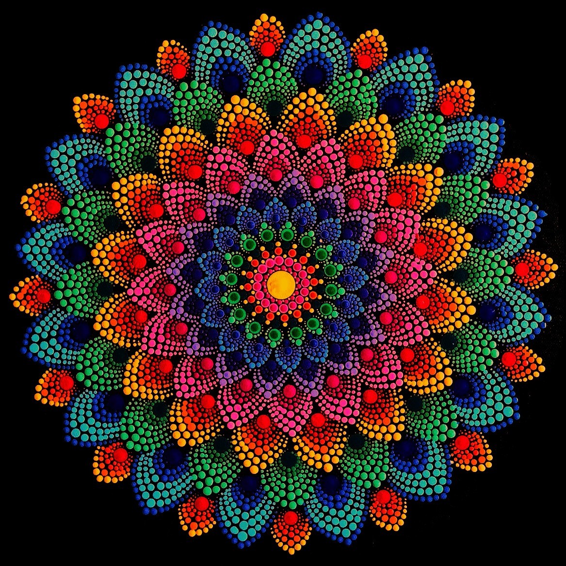 Colorful mandala with dotted petals in rainbow hues radiating from yellow center on black background