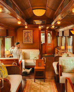 Luxurious train carriage interior with wood paneling, cream seats, and ambient lighting